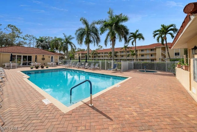 pool with a community hot tub, fence, and a patio