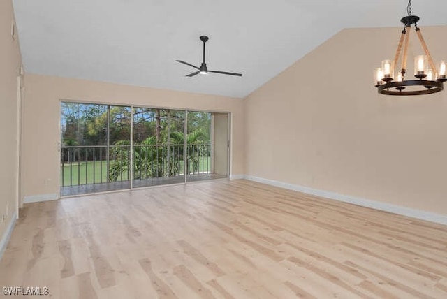 empty room with light wood-type flooring, ceiling fan with notable chandelier, and lofted ceiling