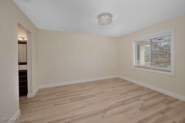 unfurnished room featuring light wood-type flooring and baseboards