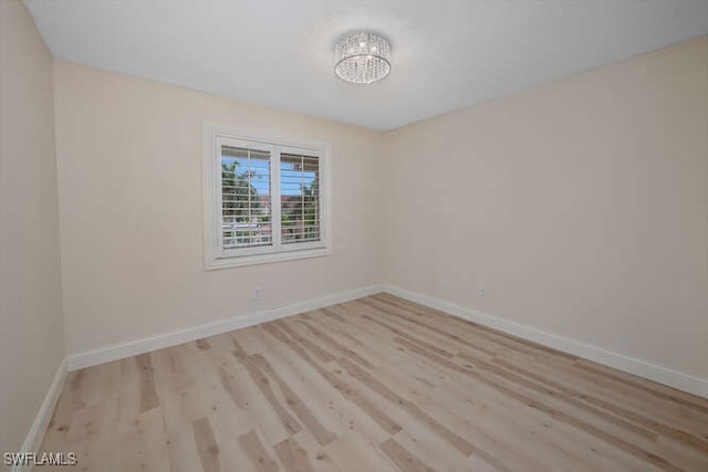 empty room with light wood finished floors and baseboards