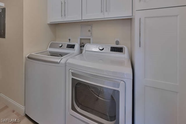 clothes washing area featuring cabinet space, electric panel, baseboards, and independent washer and dryer