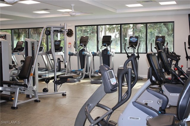 workout area featuring ceiling fan and a tray ceiling