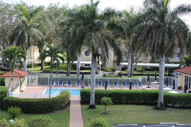 view of home's community with a yard, a swimming pool, and fence