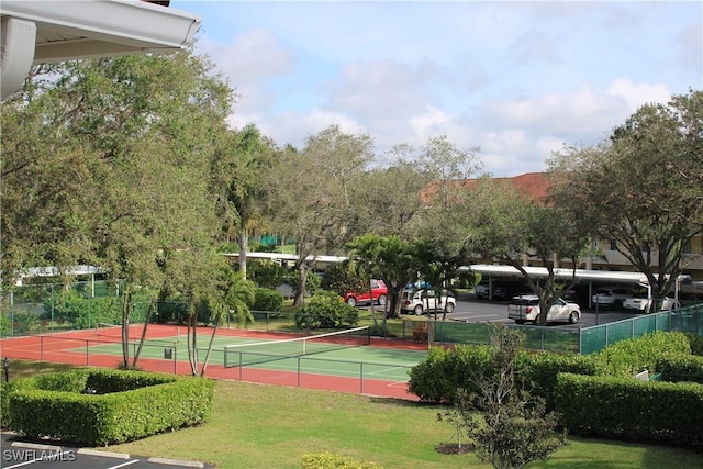 view of sport court featuring a yard and fence