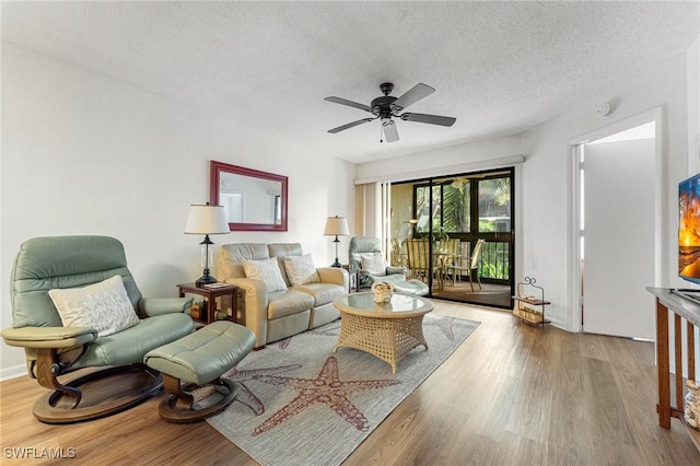 living room featuring hardwood / wood-style floors, a textured ceiling, and ceiling fan