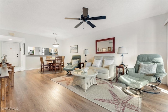 living room with ceiling fan and light hardwood / wood-style flooring