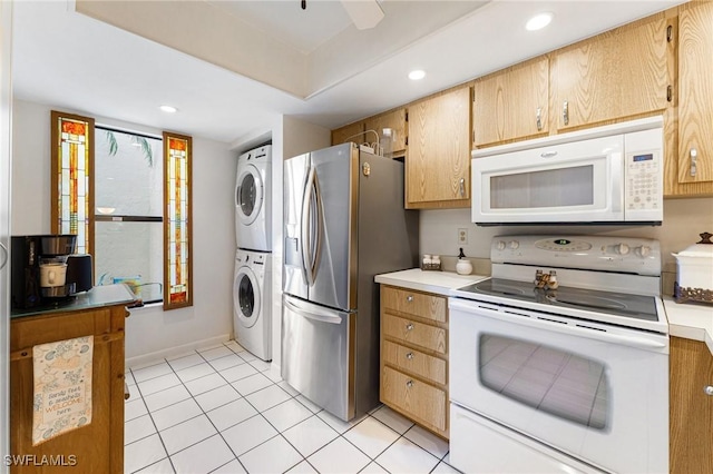 kitchen with light tile patterned flooring, white appliances, and stacked washer and clothes dryer