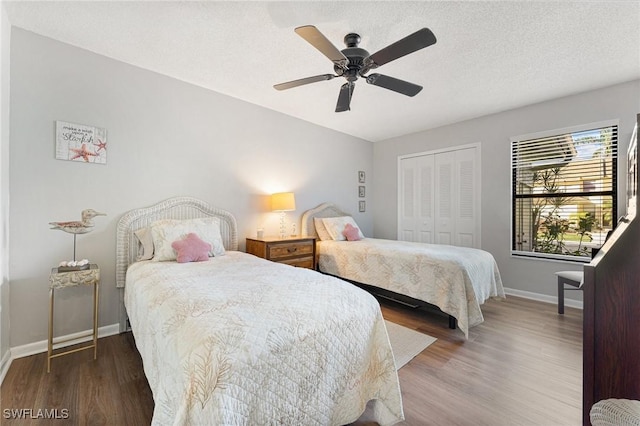 bedroom featuring ceiling fan, a closet, wood-type flooring, and a textured ceiling