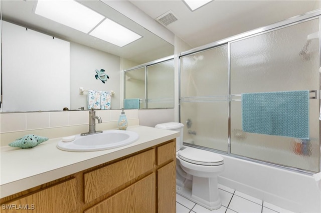 full bathroom with tile patterned floors, toilet, shower / bath combination with glass door, decorative backsplash, and vanity