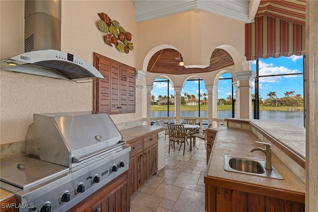 view of patio featuring area for grilling, a water view, and sink