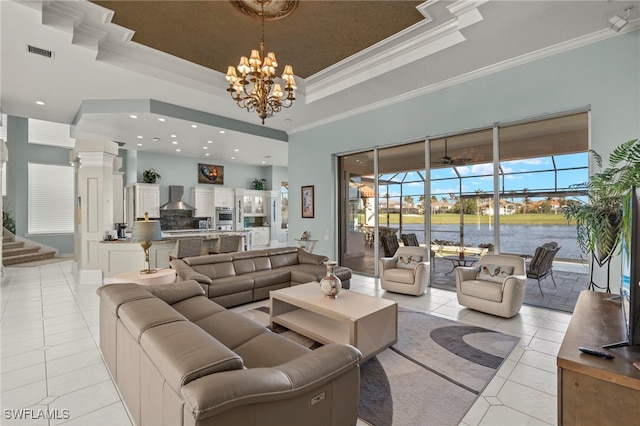 living room with a high ceiling, a tray ceiling, crown molding, and light tile patterned flooring