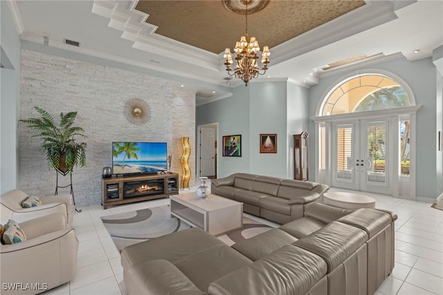 living room with a raised ceiling, crown molding, light tile patterned floors, and a chandelier