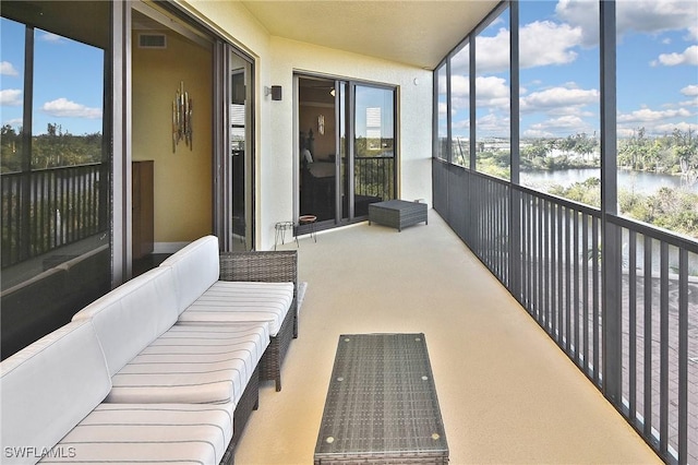 sunroom / solarium featuring a water view