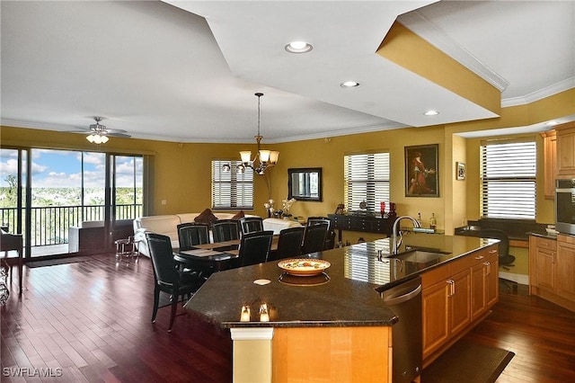 kitchen featuring ceiling fan with notable chandelier, sink, crown molding, and an island with sink