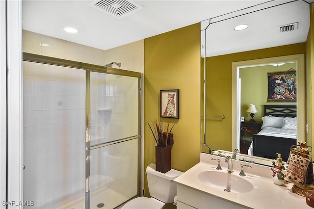 bathroom featuring vanity, toilet, and a shower with shower door