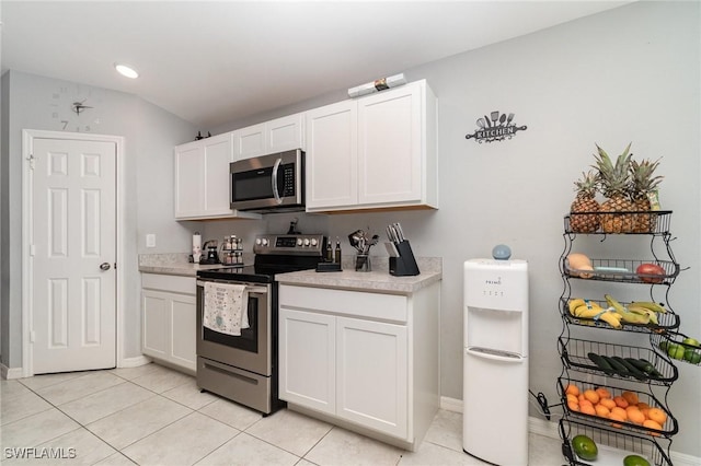 kitchen with white cabinets, appliances with stainless steel finishes, and light tile patterned flooring