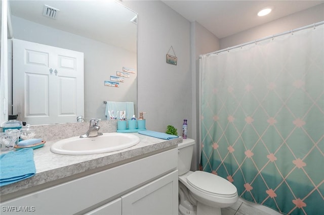 bathroom featuring toilet, vanity, and tile patterned flooring