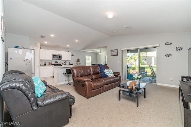 carpeted living room featuring plenty of natural light and vaulted ceiling