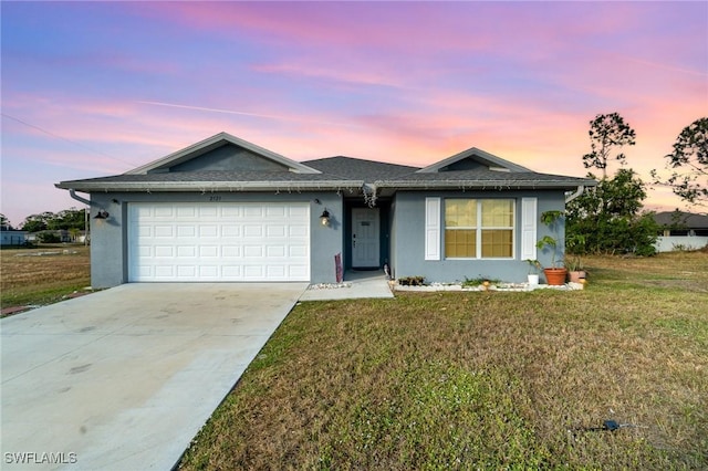 ranch-style home with a garage and a lawn