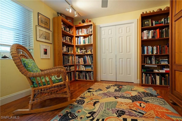 sitting room featuring hardwood / wood-style floors and rail lighting