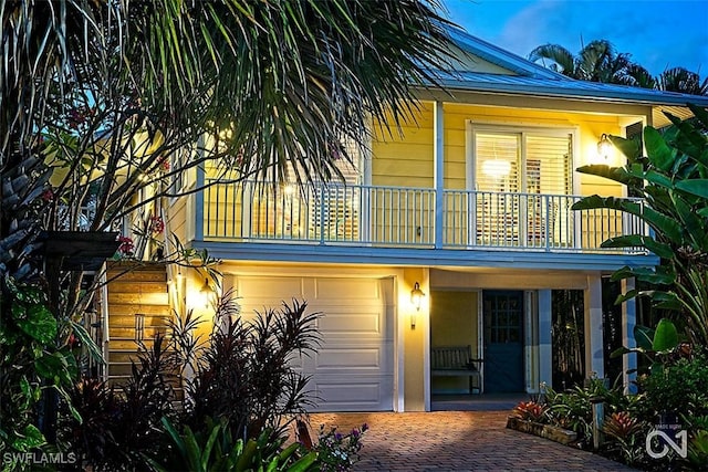 back of property featuring a balcony and a garage