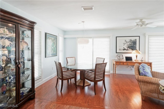 dining space with ceiling fan and dark wood-type flooring