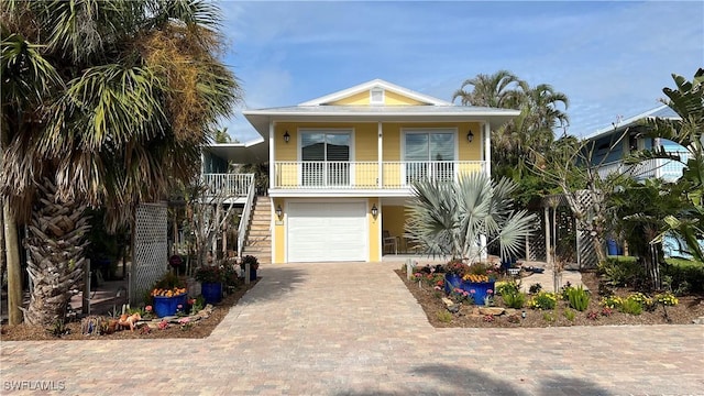 coastal home featuring a porch and a garage