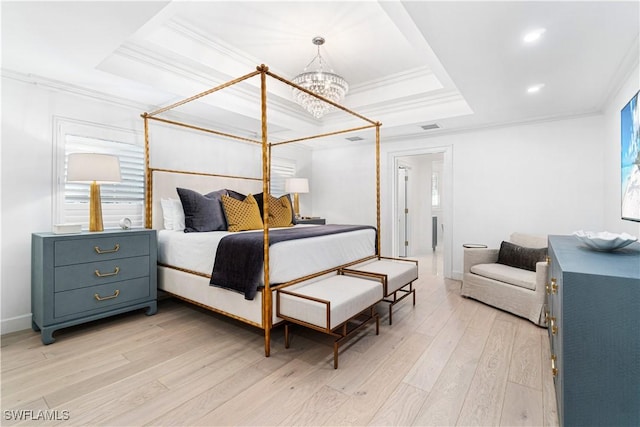 bedroom featuring a chandelier, a tray ceiling, light hardwood / wood-style flooring, and crown molding