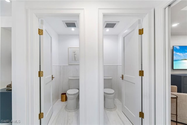 bathroom featuring toilet and tile walls