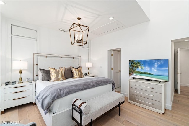 bedroom with light wood-type flooring and an inviting chandelier