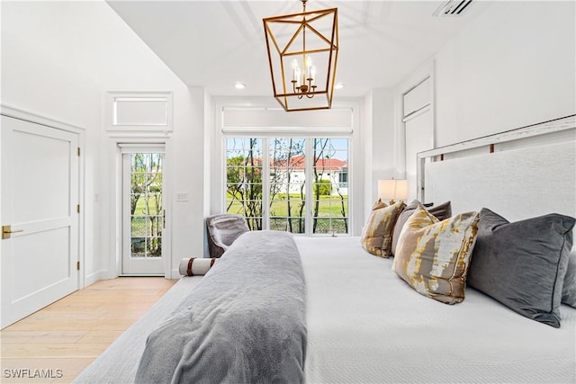 bedroom featuring access to exterior, a notable chandelier, and light wood-type flooring