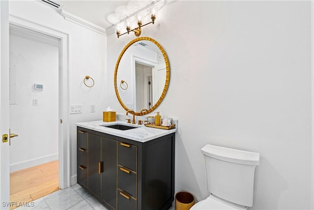 bathroom with tile patterned flooring, vanity, toilet, and ornamental molding