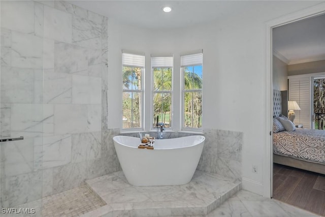 ensuite bathroom featuring ensuite bath, a soaking tub, recessed lighting, crown molding, and marble finish floor