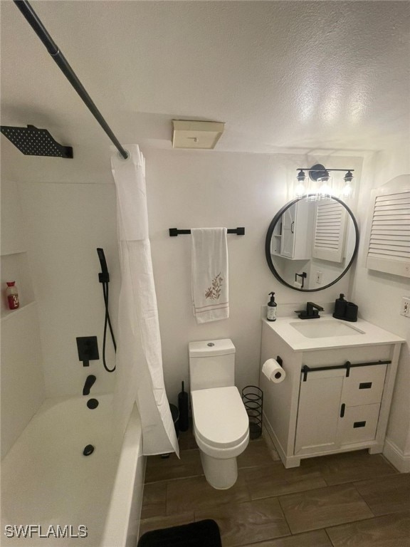 full bathroom with vanity, toilet, shower / bath combo with shower curtain, and a textured ceiling