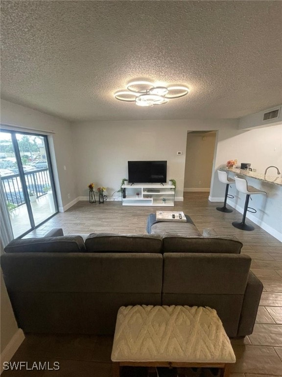 living room featuring a textured ceiling, hardwood / wood-style flooring, and sink