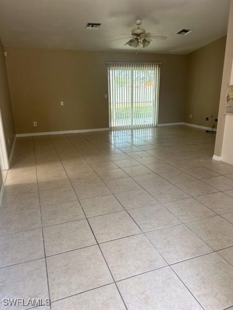 empty room with ceiling fan and light tile patterned floors