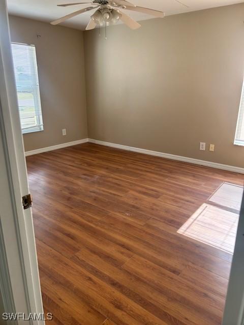 empty room featuring ceiling fan and dark wood-type flooring