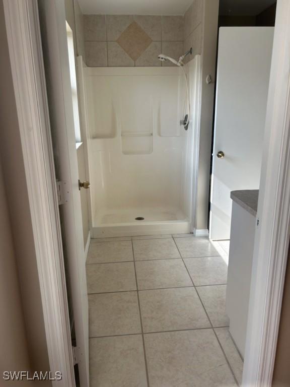 bathroom with tile patterned flooring and walk in shower