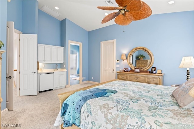 bedroom featuring high vaulted ceiling, sink, ensuite bath, ceiling fan, and light colored carpet