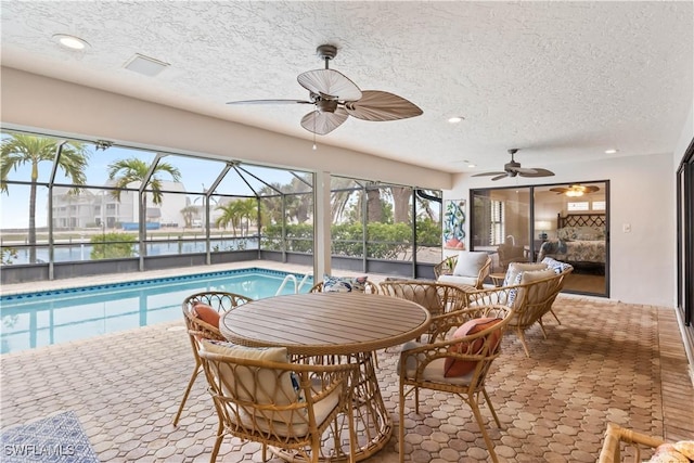 interior space featuring a water view, a pool, and ceiling fan