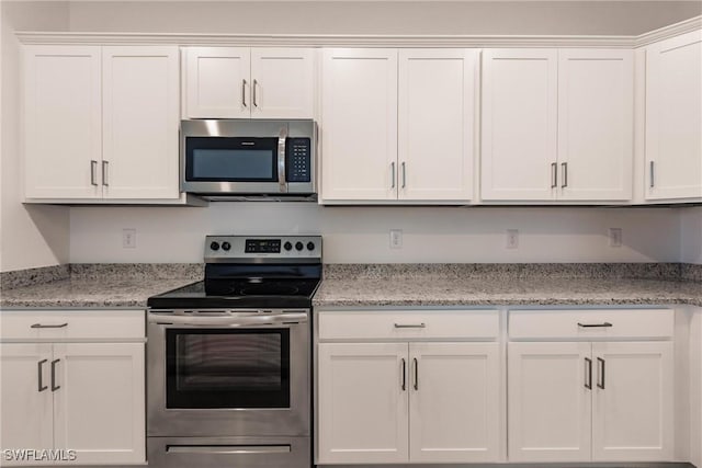 kitchen with appliances with stainless steel finishes, white cabinetry, and light stone counters