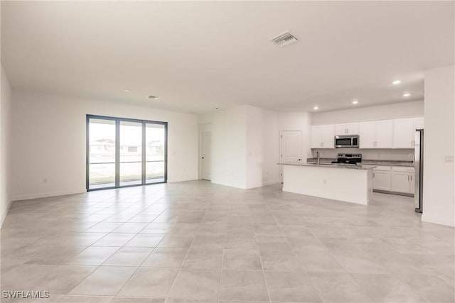 unfurnished living room with sink and light tile patterned flooring