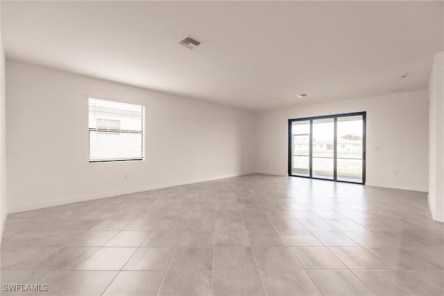 tiled empty room featuring a healthy amount of sunlight