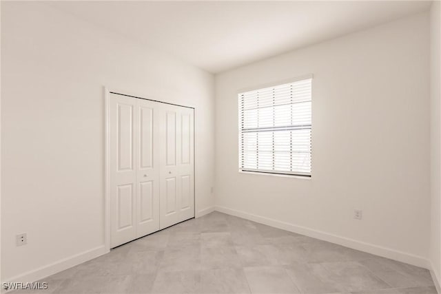 unfurnished bedroom with light tile patterned floors and a closet