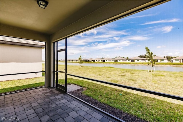 unfurnished sunroom featuring a water view