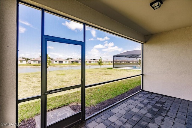 unfurnished sunroom featuring a water view