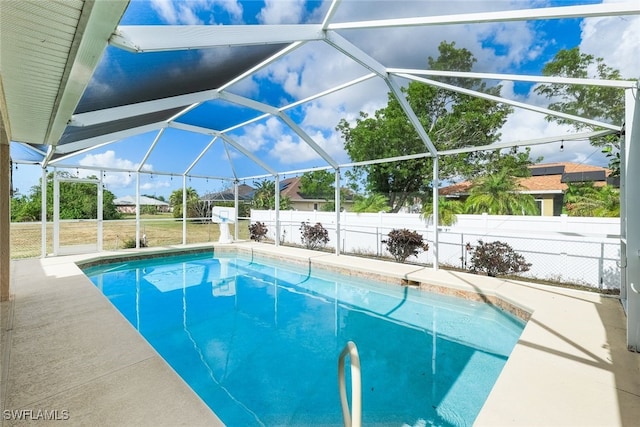 view of swimming pool featuring glass enclosure