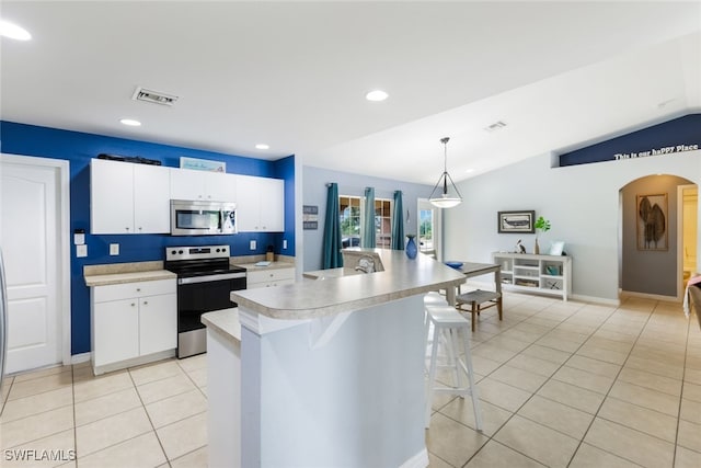 kitchen featuring white cabinetry, hanging light fixtures, vaulted ceiling, and appliances with stainless steel finishes