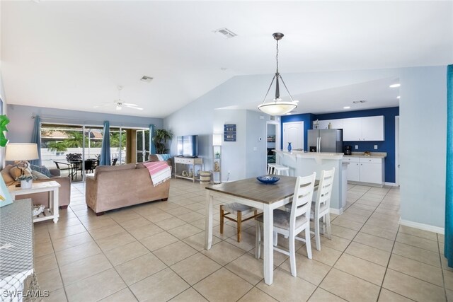 tiled dining space with ceiling fan and lofted ceiling