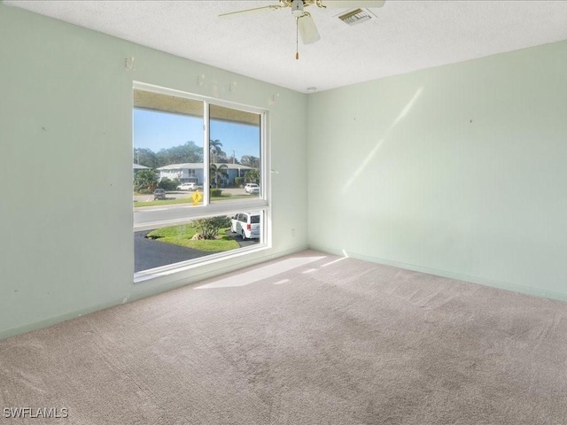 unfurnished room featuring a textured ceiling, carpet floors, and ceiling fan